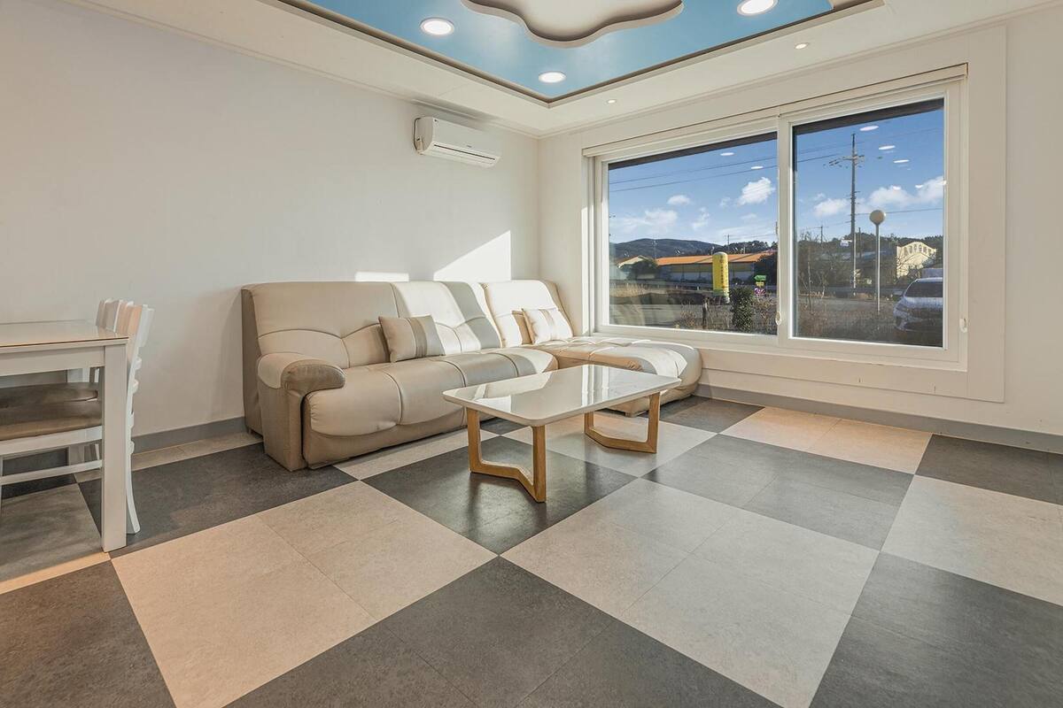 Una sala moderna con un sofá, una mesa de centro y una mesa de comedor.