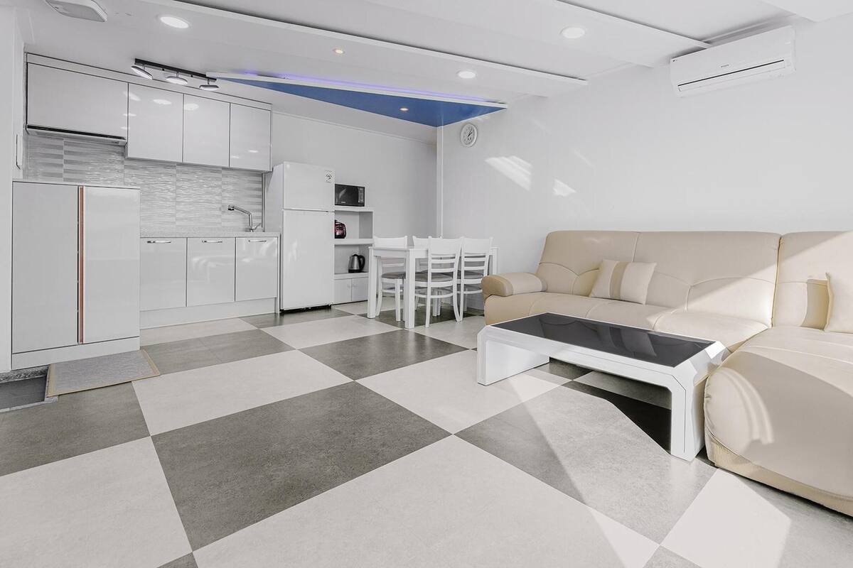 Una sala de estar moderna con sofá, mesa de centro y comedor.