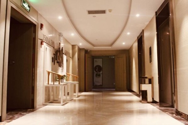 A hotel corridor with a marble floor, a reception desk, and a door at the end. - Ruijiang International Hotel (Sandu)
