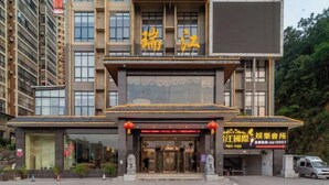 A modern building with a traditional architectural style, featuring a prominent entrance with a glass facade and a sign with Chinese characters. - Ruijiang International Hotel (Sandu)