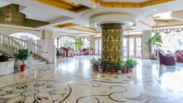 A spacious lobby with a marble floor, a central column, and a staircase leading to upper levels. - Yifeng Hotel (Yifeng)
