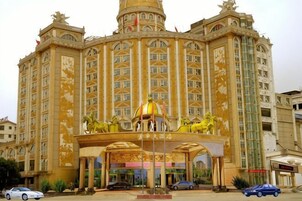 Un gran hotel ornamentado con una entrada central, varios pisos y una estructura de cúpula destacada.