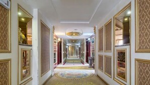 A long, narrow hallway with ornate wall panels and a patterned carpet. - Yifeng Hotel (Yifeng)