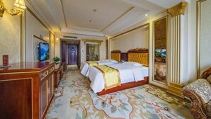 A hotel room with a large bed, a desk, a television, and a decorative mirror. - Yifeng Hotel (Yifeng)