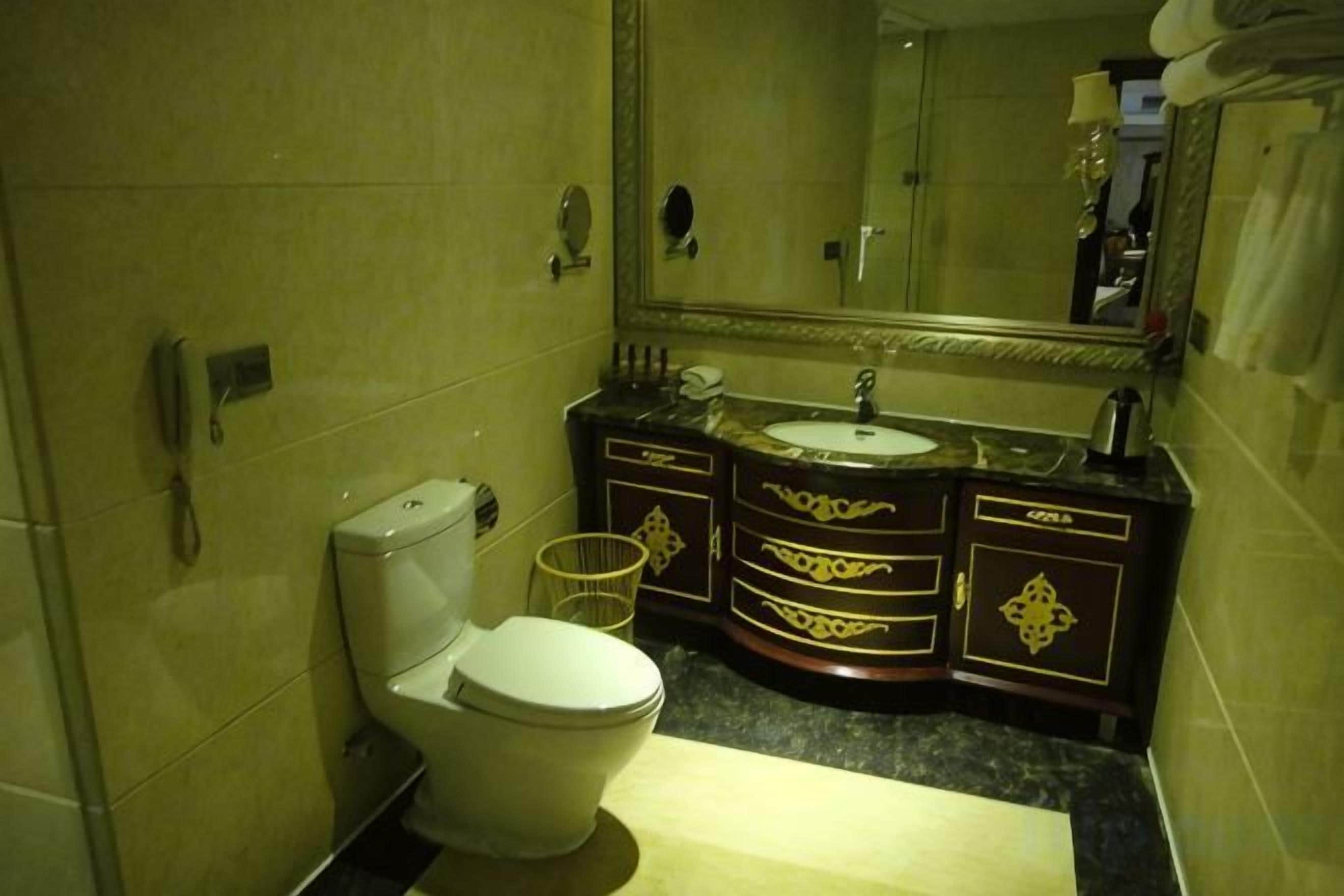 Un baño con inodoro, lavamanos y espejo.
