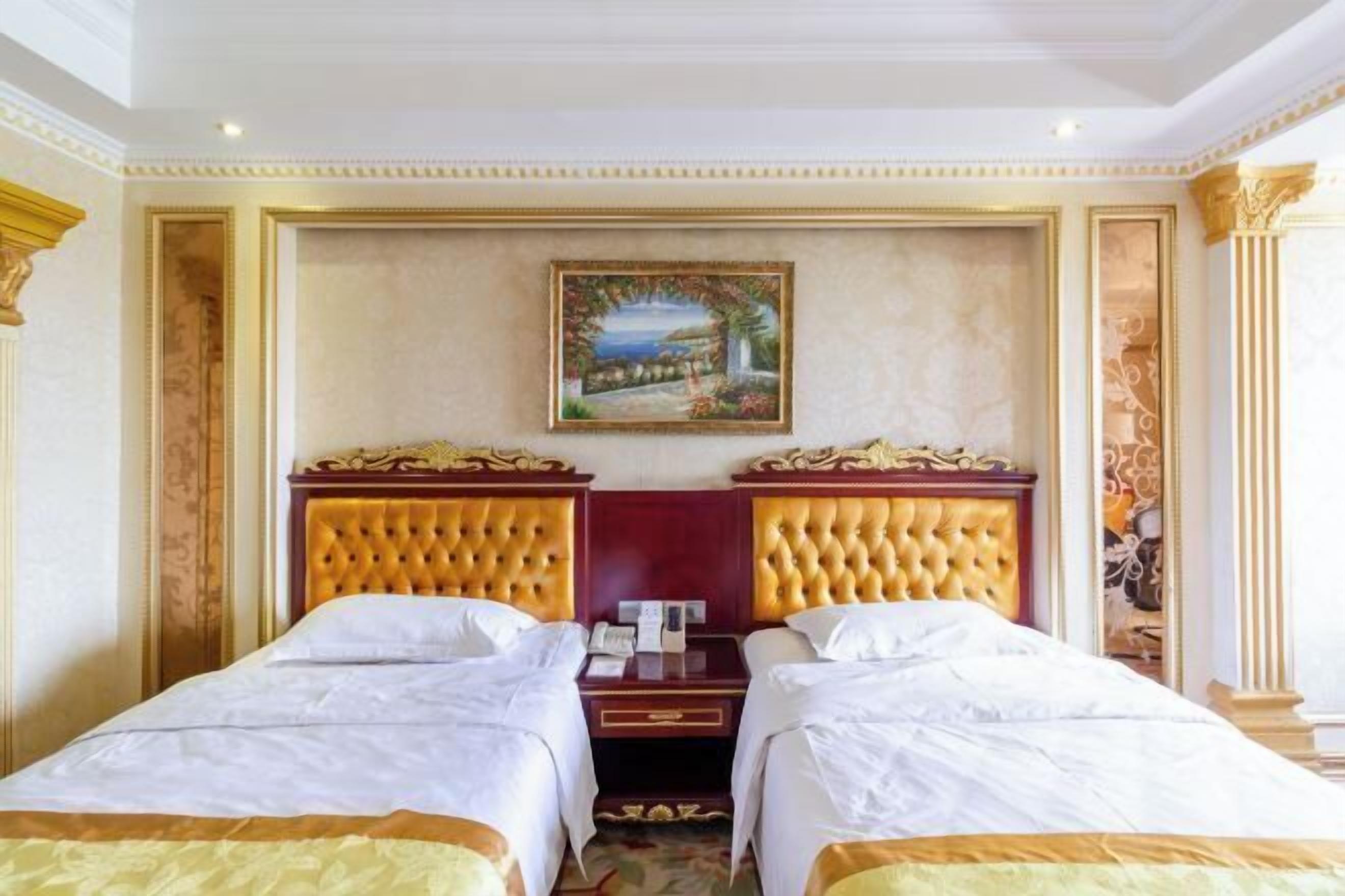 Una habitación de hotel con dos camas, un cuadro en la pared y una decoración elaborada.
