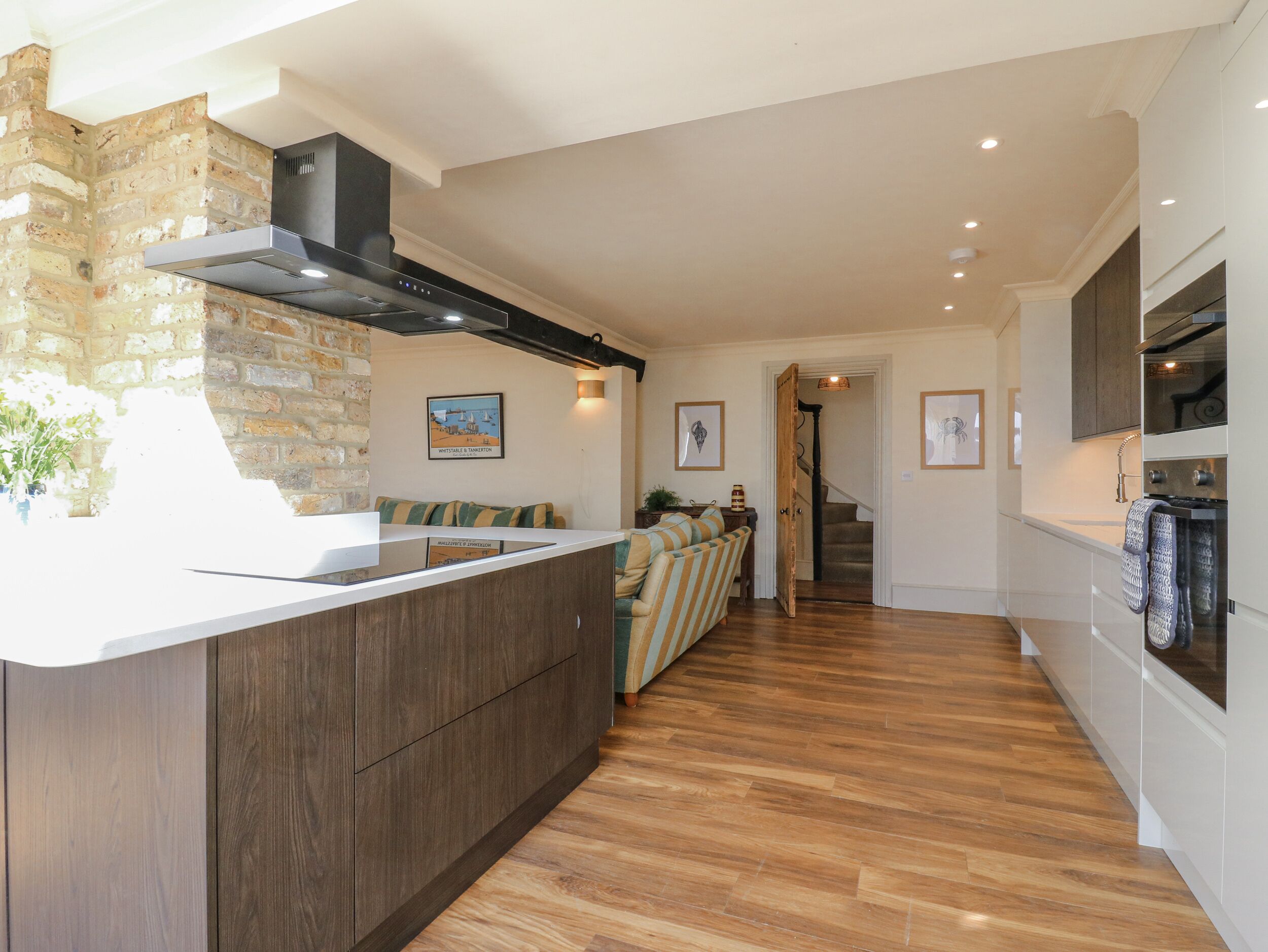 Una cocina moderna con una pared de acento de piedra, armarios de madera y una isla integrada.