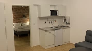 A compact living space with a kitchenette, a dining area, and a bedroom.