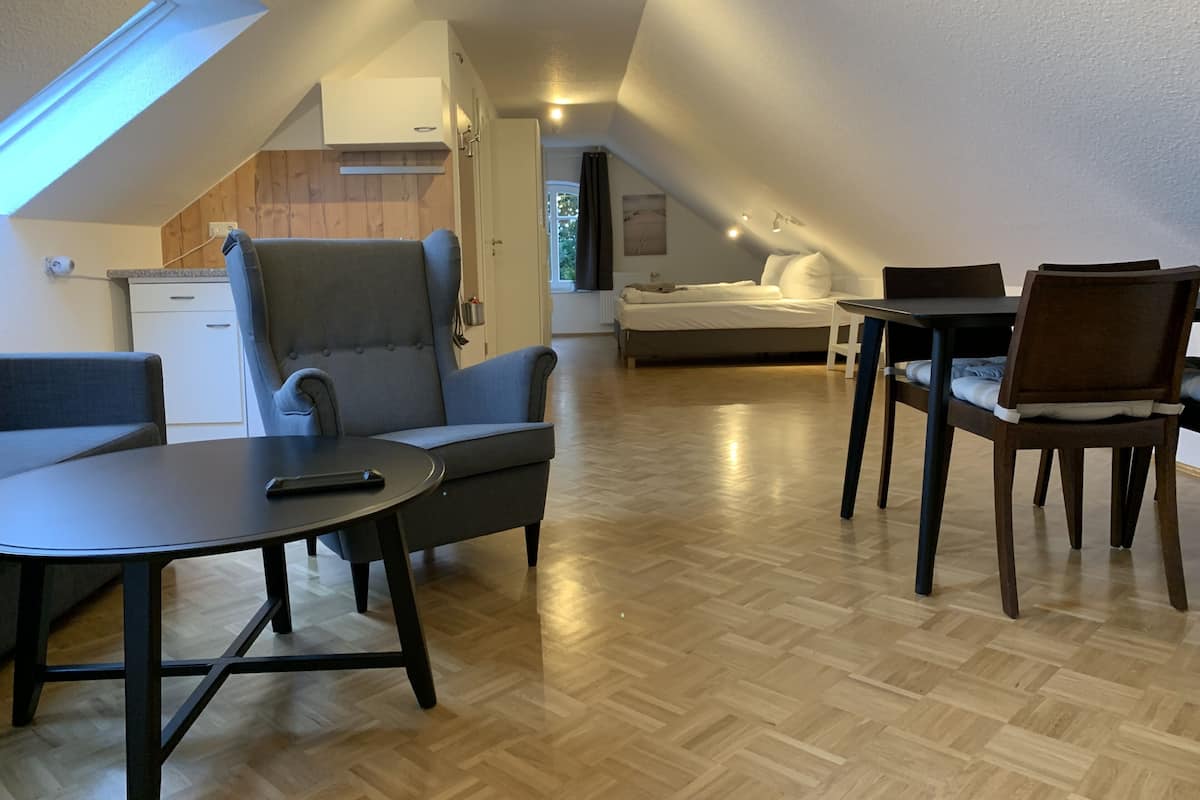 Una habitación moderna estilo loft con comedor, sofá y cama.
