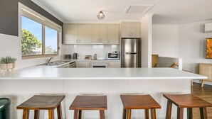 A modern kitchen with a large island, stainless steel appliances, and a view of the outdoors. - Bass River Farm 9 mins from Phillip Island (Bass)