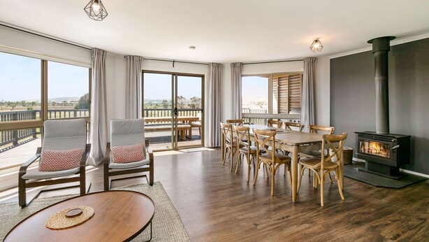 A spacious living area with a dining table, chairs, a sofa, and a fireplace. - Bass River Farm 9 mins from Phillip Island (Bass)