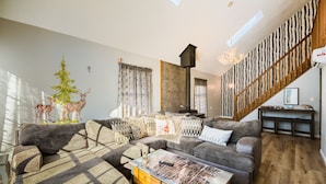 A modern living room with a sectional sofa, a coffee table, and a fireplace. - BRAND NEW HOT TUB-SAUNA-2 WEBER GRILLS-FIRE PIT-AC-THERMOMIX (Long Pond)