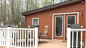 A wooden deck with a white railing, a bench, and a table with chairs. - BRAND NEW HOT TUB-SAUNA-2 WEBER GRILLS-FIRE PIT-AC-THERMOMIX (Long Pond)