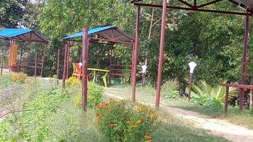 Un jardín con estructuras metálicas y un sendero de tierra.