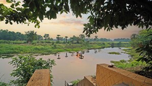 A riverside view with a bridge and lush greenery. - Neel Nirjan Resort (Bolpur)