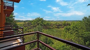 A balcony with a view of a lush green landscape and a clear blue sky. - Neel Nirjan Resort (Bolpur)