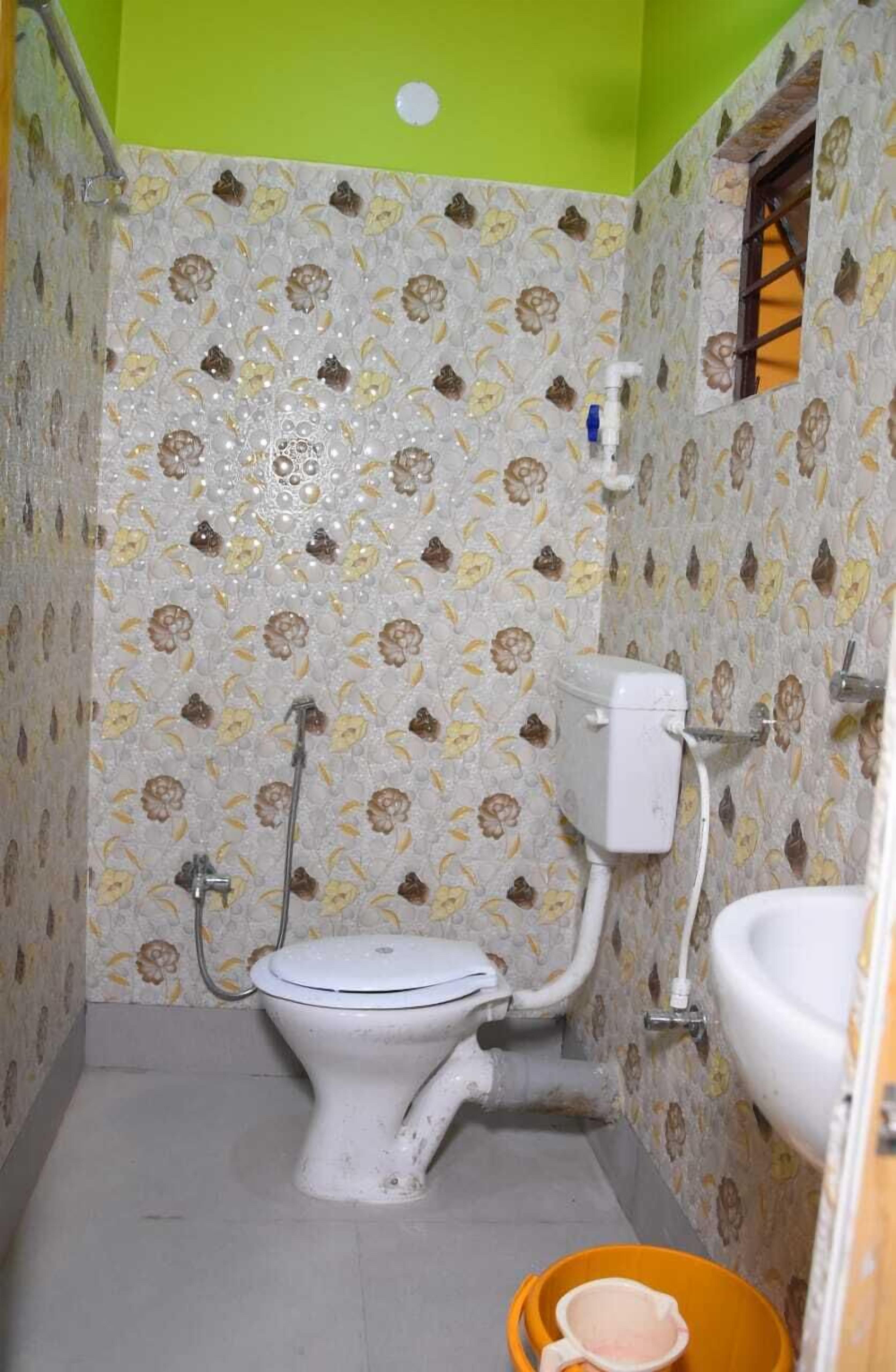 A small bathroom with a toilet, sink, and shower.