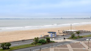 Uitzicht op een strand met een klein paviljoen, een zebrapad en een weg naar het strand.
