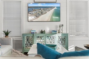 Relax in this stylish living room with a large flat-screen TV, comfortable sofa, and a console table.