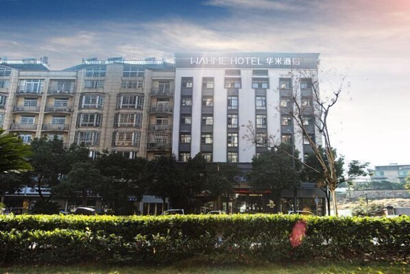 A multi-story hotel with a modern facade, featuring a prominent signage at the top. - Wahme Light Hotel (Shangrao)