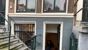 Ein zweistöckiges Gebäude mit einem sichtbaren Eingang und einer Treppe zum oberen Stockwerk.