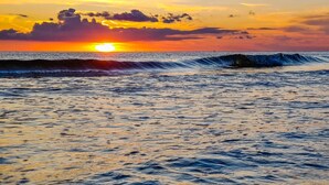 A sunset over the ocean with waves. - Made in Shade B · Beach Across St · Pets OK (Holmes Beach)