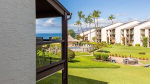 A resort with multiple buildings, a pool area, and a view of the ocean.