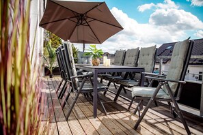 An outdoor patio with a table, chairs, and an umbrella.