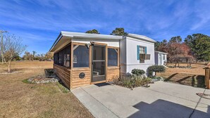 A single-story house with a covered porch, a front door, and a small front yard. - Pet-Friendly Cabin w/ Dock: Fish & Explore! (Oriental)