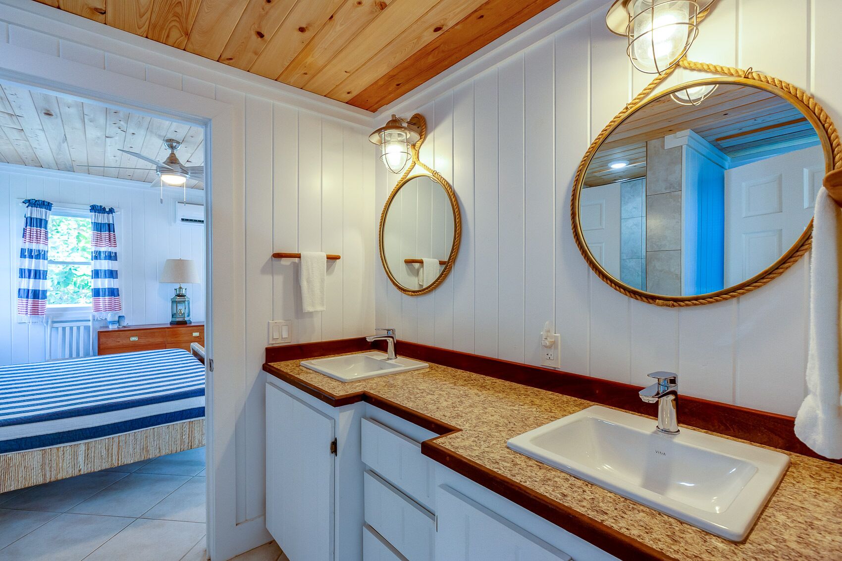 Un baño con dos lavamanos, un espejo y un ventilador de techo.