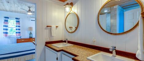 Un baño con dos lavamanos, un espejo y un ventilador de techo.