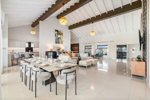 A spacious living area with a high ceiling, a dining table set for six, and a comfortable seating arrangement. - Ocean Front! 8BR Villa with Pool near Malmok Beach (Malmok)