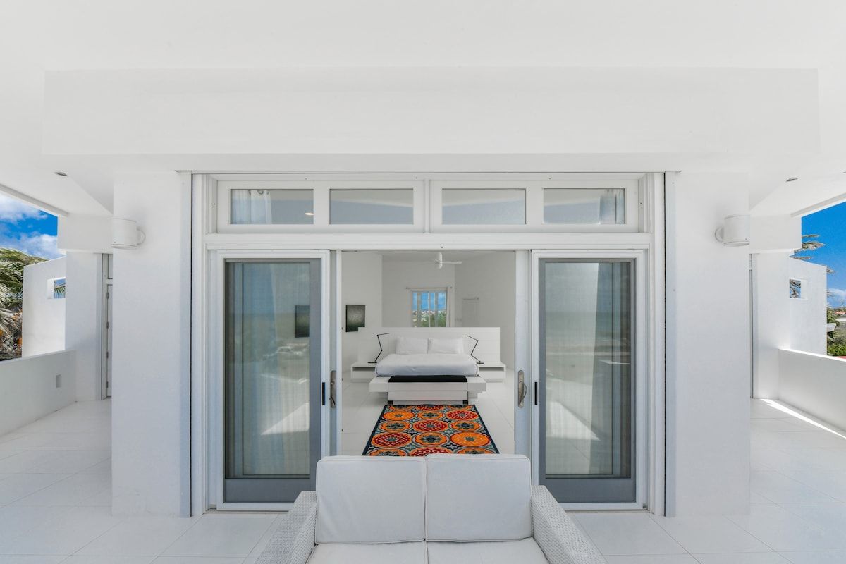 Un intérieur moderne avec un lit, un canapé et un tapis à motifs.