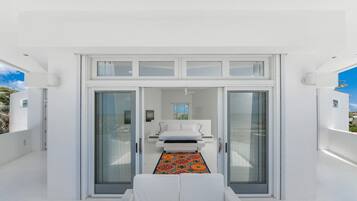 Un intérieur moderne avec un lit, un canapé et un tapis à motifs.