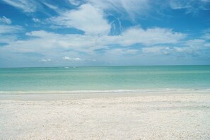 Een strand met helder turquoise water en een zandstrand.