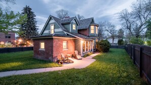 A two-story house with a brick facade, a covered porch, and a well-maintained lawn.