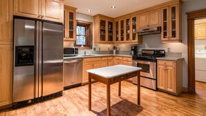 A kitchen with wooden cabinets, stainless steel appliances, and a central island.