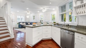 A modern kitchen with white cabinetry, a dishwasher, and a granite countertop. - A KEY ESCAPE ~ 3 Bedroom, 2.5 Bathroom Home in Old Town /Private Heated Pool! (Key West)