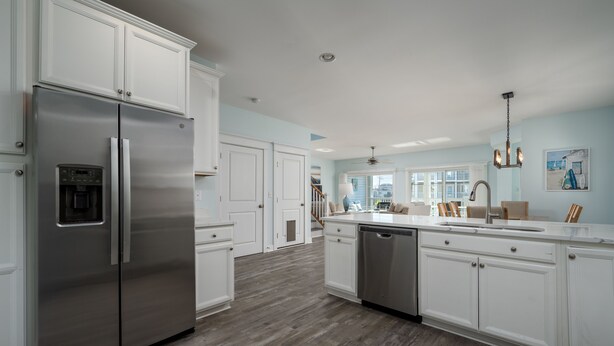 A modern kitchen with white cabinetry, stainless steel appliances, and a wooden floor. - WALK TO BEACH -  5 BR, DOG-FRIENDLY BEAUTY - 101 SWEDES ST, DEWEY BEACH (Dewey Beach)