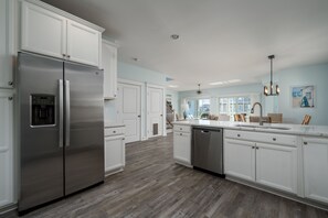 A modern kitchen with white cabinetry, stainless steel appliances, and a wooden floor. - WALK TO BEACH -  5 BR, DOG-FRIENDLY BEAUTY - 101 SWEDES ST, DEWEY BEACH (Dewey Beach)