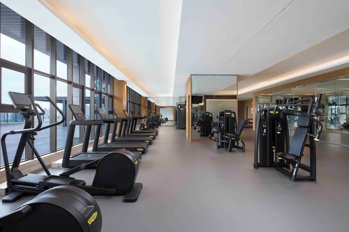 A gym with treadmills, elliptical machines, and weight equipment.