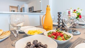 A dining table with various dishes, a bottle of champagne, and wine glasses. - Chic Waterfront Retreat | Panoramic Intracoastal Views (Sunny Isles Beach)