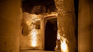 A narrow, dimly lit passageway with rough stone walls and a door at the end. - Pome Granate Cave Hotel (Nevsehir)