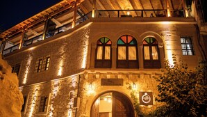 A stone building with a wooden door and arched windows, labeled "POM GRANALÉ CAVE HOTEL". - Pome Granate Cave Hotel (Nevsehir)