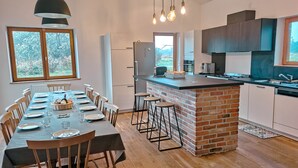 Een moderne keuken met een centraal eiland, een houten eettafel en stoelen.