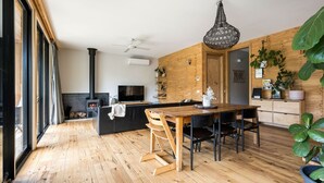 A modern kitchen with a central island, wooden flooring, and a black stove. - One Bright Stay in beautiful Bright (Bright)