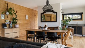 A modern kitchen with wooden cabinetry, a dining table with chairs, and a large mirror above the table. - One Bright Stay in beautiful Bright (Bright)