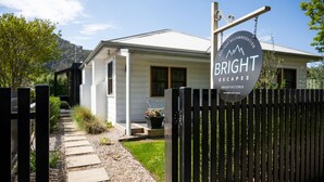 A two-story house with a white exterior, a front porch, and a wooden gate. - One Bright Stay in beautiful Bright (Bright)