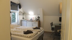 A bedroom with two beds, a desk, and a chair. - Apartment am Wall (Emden)
