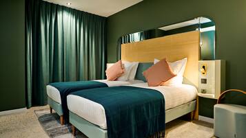 Een tweepersoonsbed met een houten hoofdeinde, twee nachtkastjes en een bijzettafeltje.